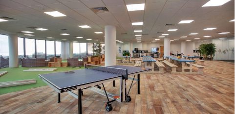 Office break area with wooden benches and table tennis