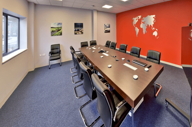 Large boardroom table in Poole with orange wall and map of the world