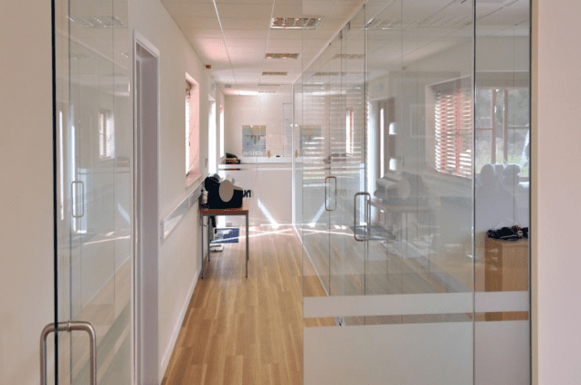 HWM Group office refurbishment hallway beside glass partitioned office areas